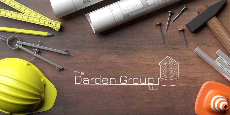 construction tools and drawings with the darden group logo on the table